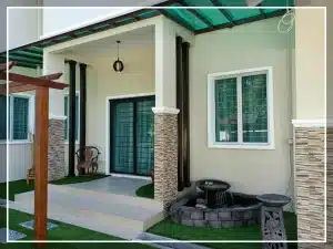 Modern house entrance with small garden and water fountain, featuring stone wall accents and sliding glass doors.