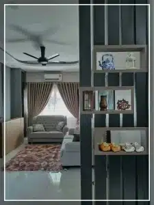 Cozy living room with beige sofa, decorative shelves, ceiling fan, and elegant curtains.