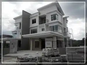 Modern two-story house under construction with glass windows and grey accents, featuring an unfinished driveway.