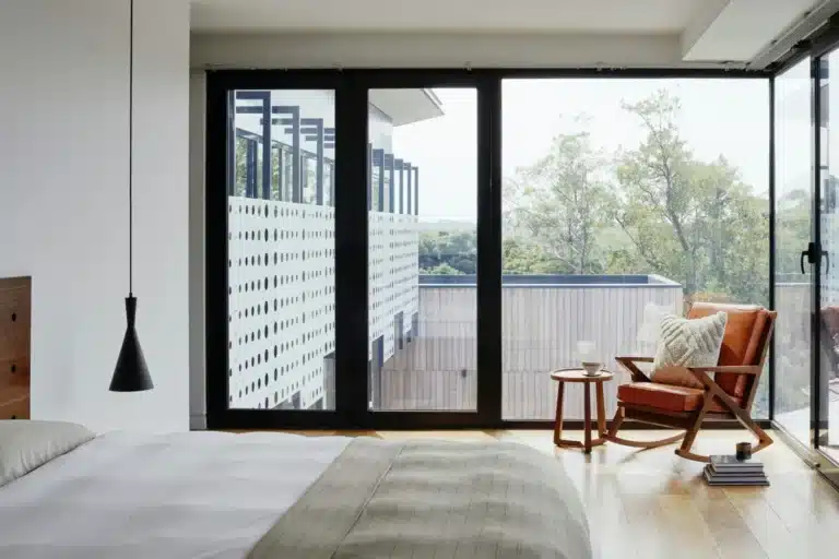Proses Pembiayaan Rumah Lambat? Rahsia PERCEPAT 2X Lipat Permohonan Koperasi Anda Sekarang! 19 Modern bedroom with large windows, cozy chair, and wooden floors overlooking a lush view. Minimalist design.