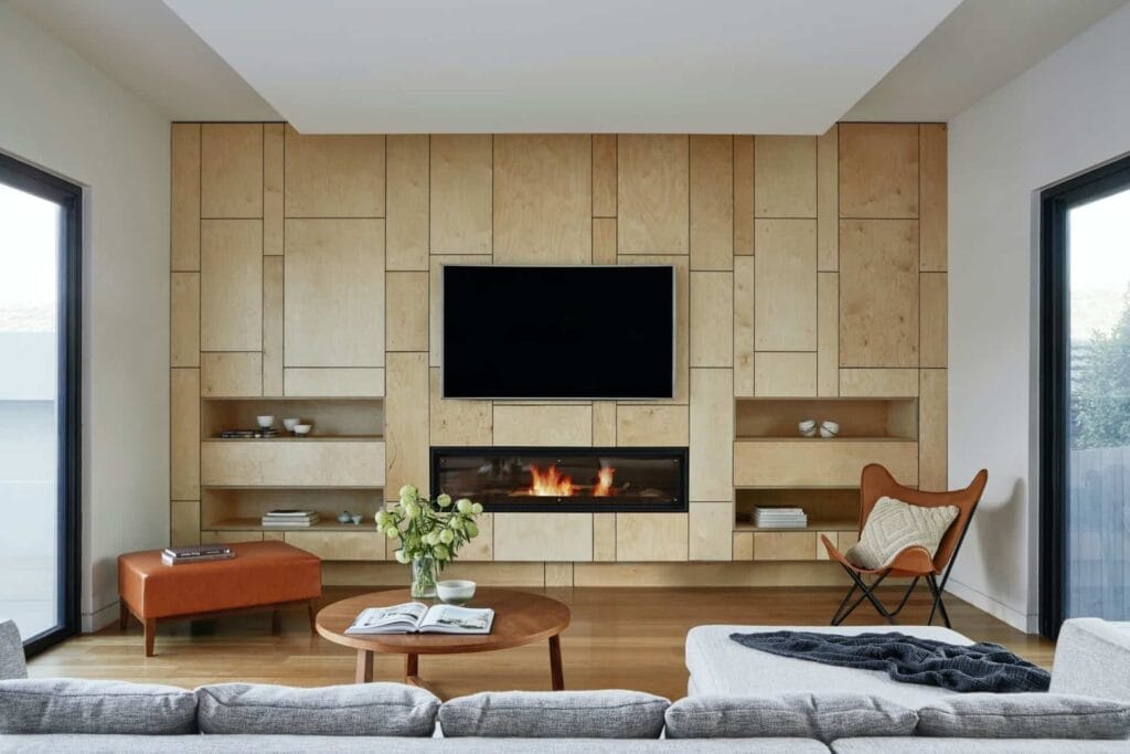 Modern living room with wooden feature wall, fireplace, TV, and cozy seating. Stylish, functional space design.