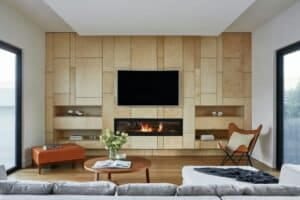 Modern living room with wooden paneling, cozy fireplace, and minimalist furniture design.