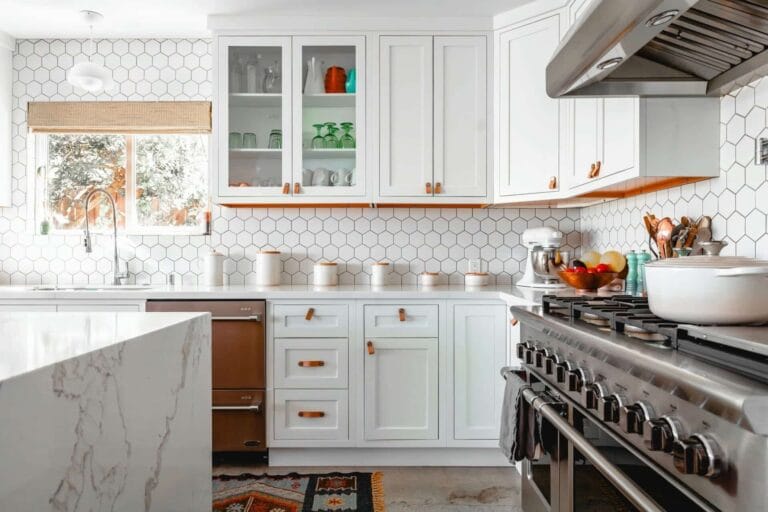 7 Rahsia "Front Yard hacks" Yang Semua Orang Tak Beritahu – Ubah Muka Rumah Anda Jadi Lebih Selesa, Sejuk & Menawan Dalam Masa 7 Hari! 28 Modern kitchen with white cabinets, hexagonal tiles, stainless steel appliances, and a large countertop.